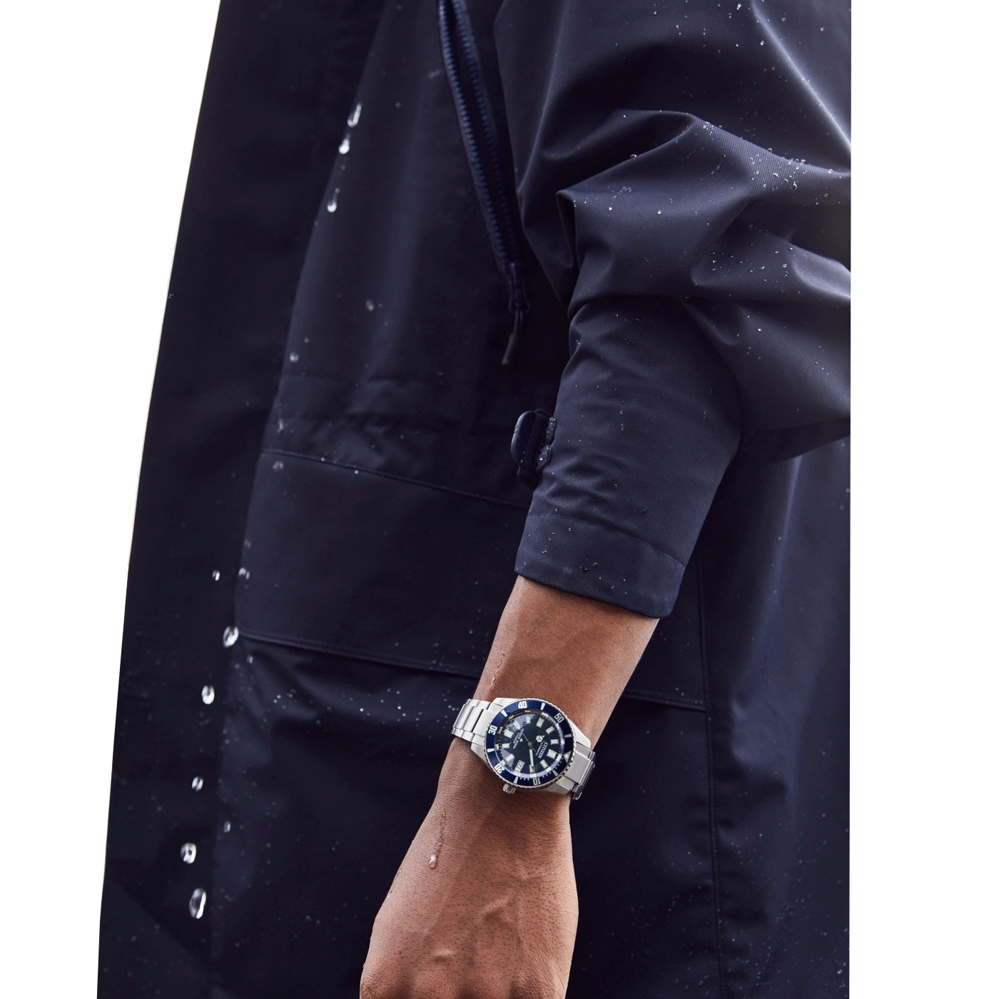 Man wearing a watch, dark blue jacket, water droplets, close-up shot, wrist