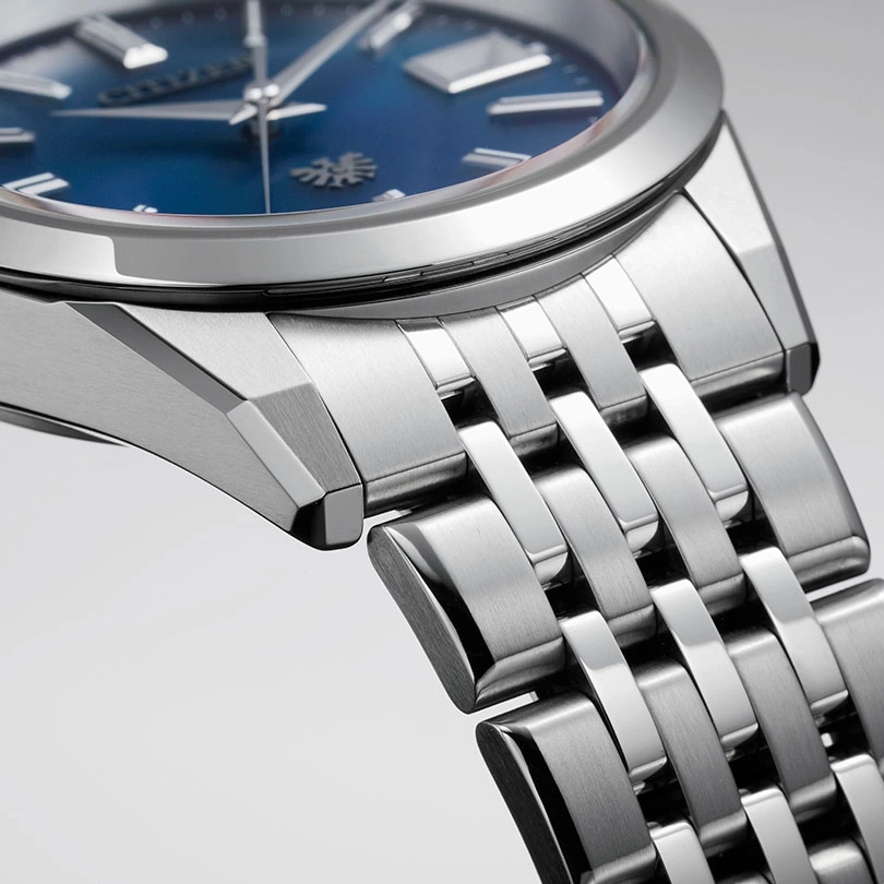 Close-up of a silver watch with a blue face and metal band.