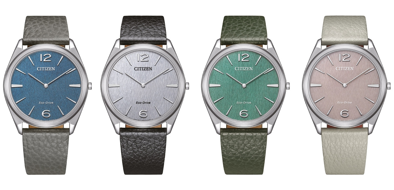 Four Citizen watches with different colored faces and leather straps.