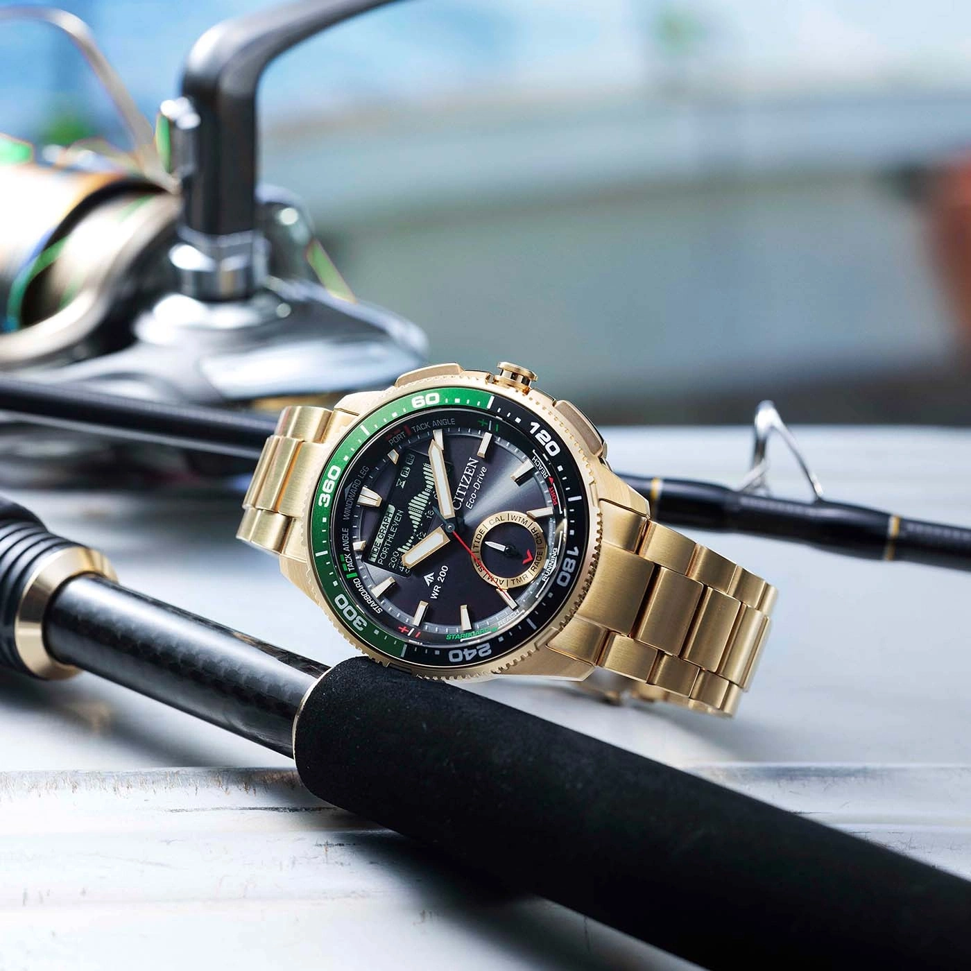 A gold Citizen Eco-Drive watch rests on fishing rods.