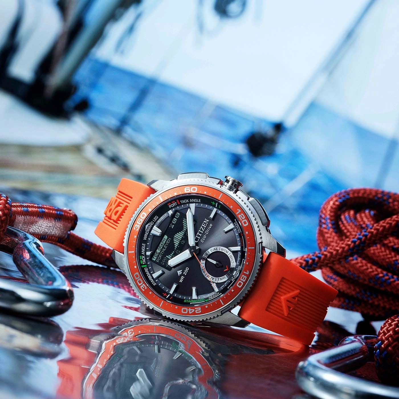 A close-up shot of a Citizen Eco-Drive watch with an orange strap, set amongst sailing ropes and carabiners.