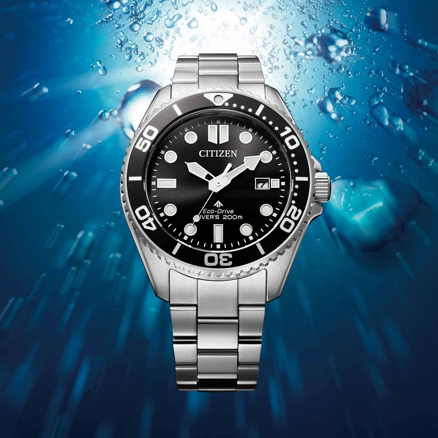 Citizen watch with black dial and silver strap, underwater background.