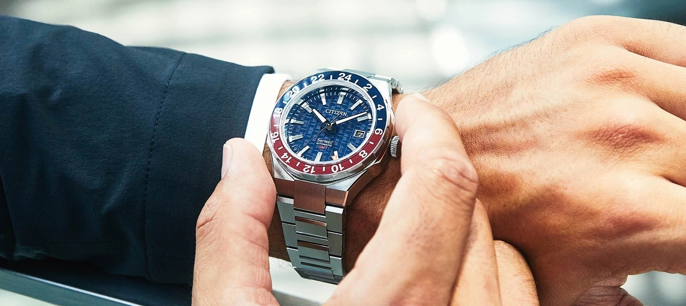 Close-up of a man's wrist with a Citizen watch, showing the watch's details.