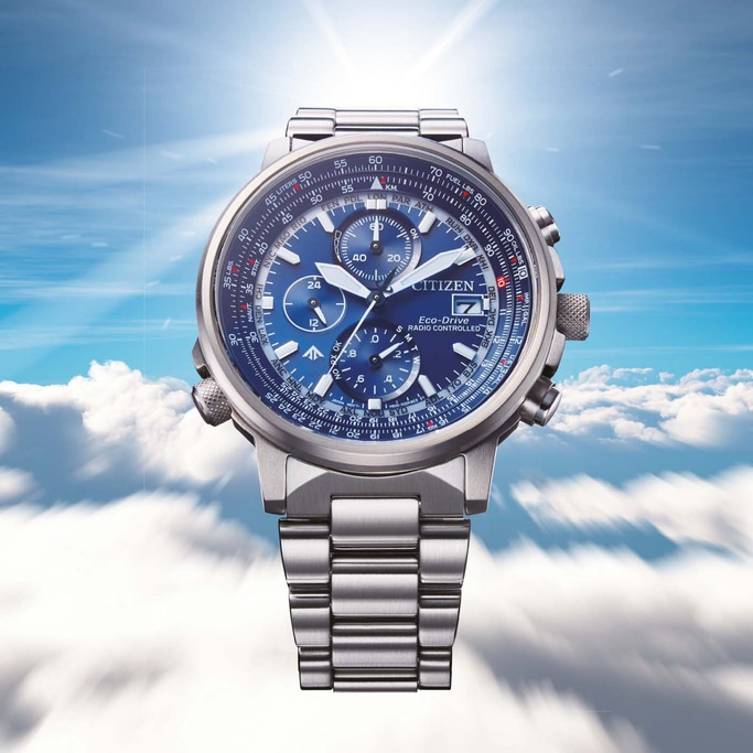 Citizen watch with blue face, silver band, and multiple dials against a cloudy sky.