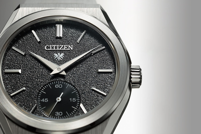 Nahaufnahme einer Citizen-Uhr mit strukturiertem schwarzem Zifferblatt und silbernen Zeigern.