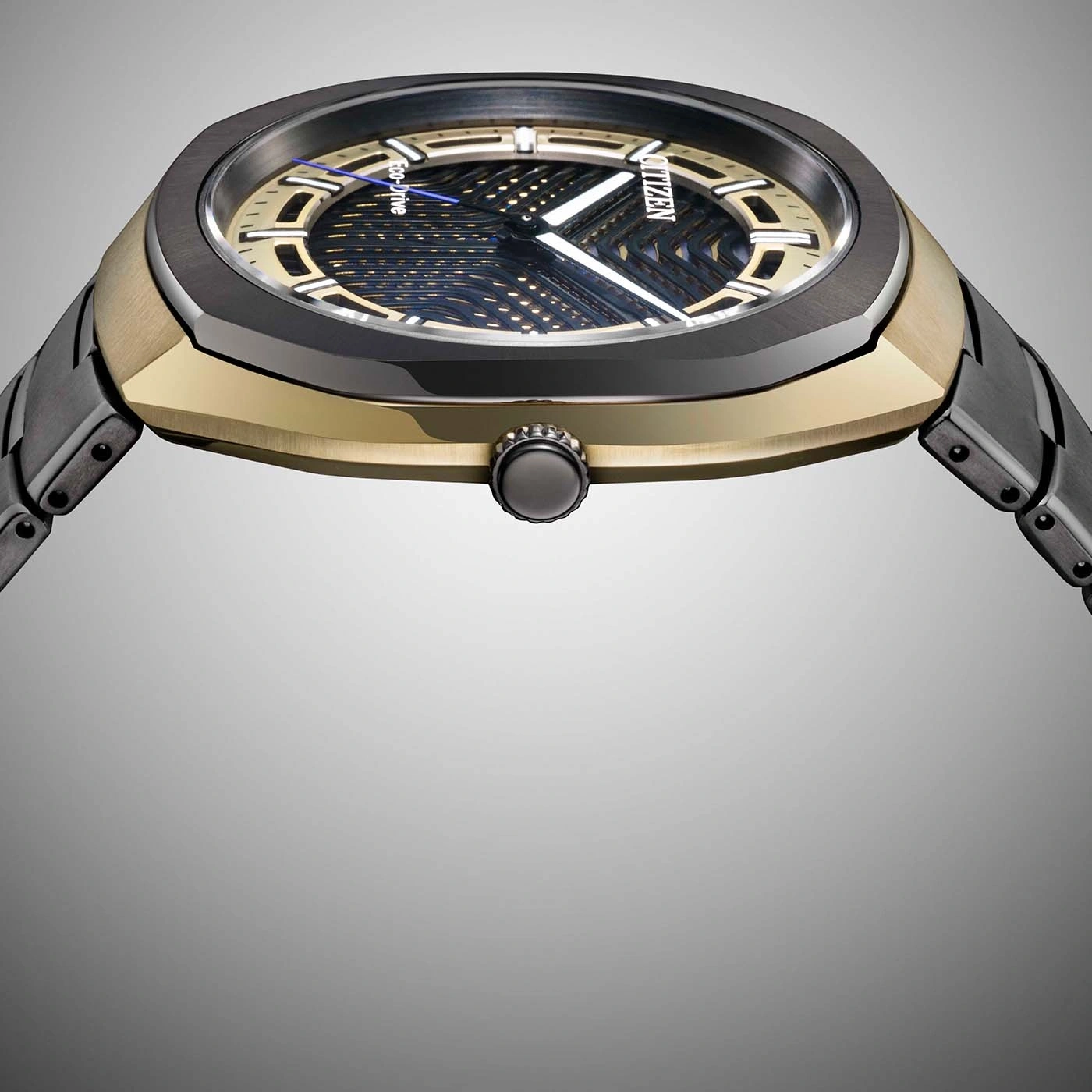 A modern, dark-toned watch with a gold accent and intricate dial.