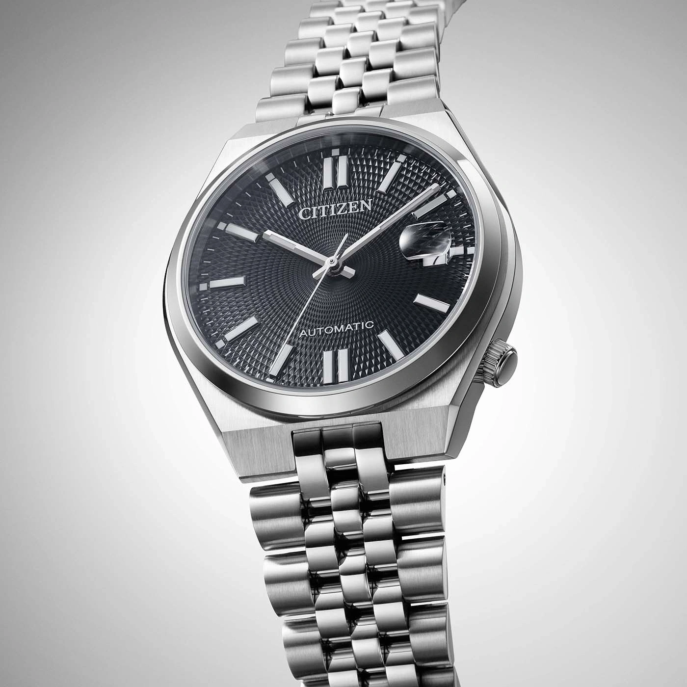 Close-up of a stainless steel Citizen automatic watch with a black dial.