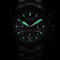 A black Citizen Eco-Drive watch with glowing green hands and markers.