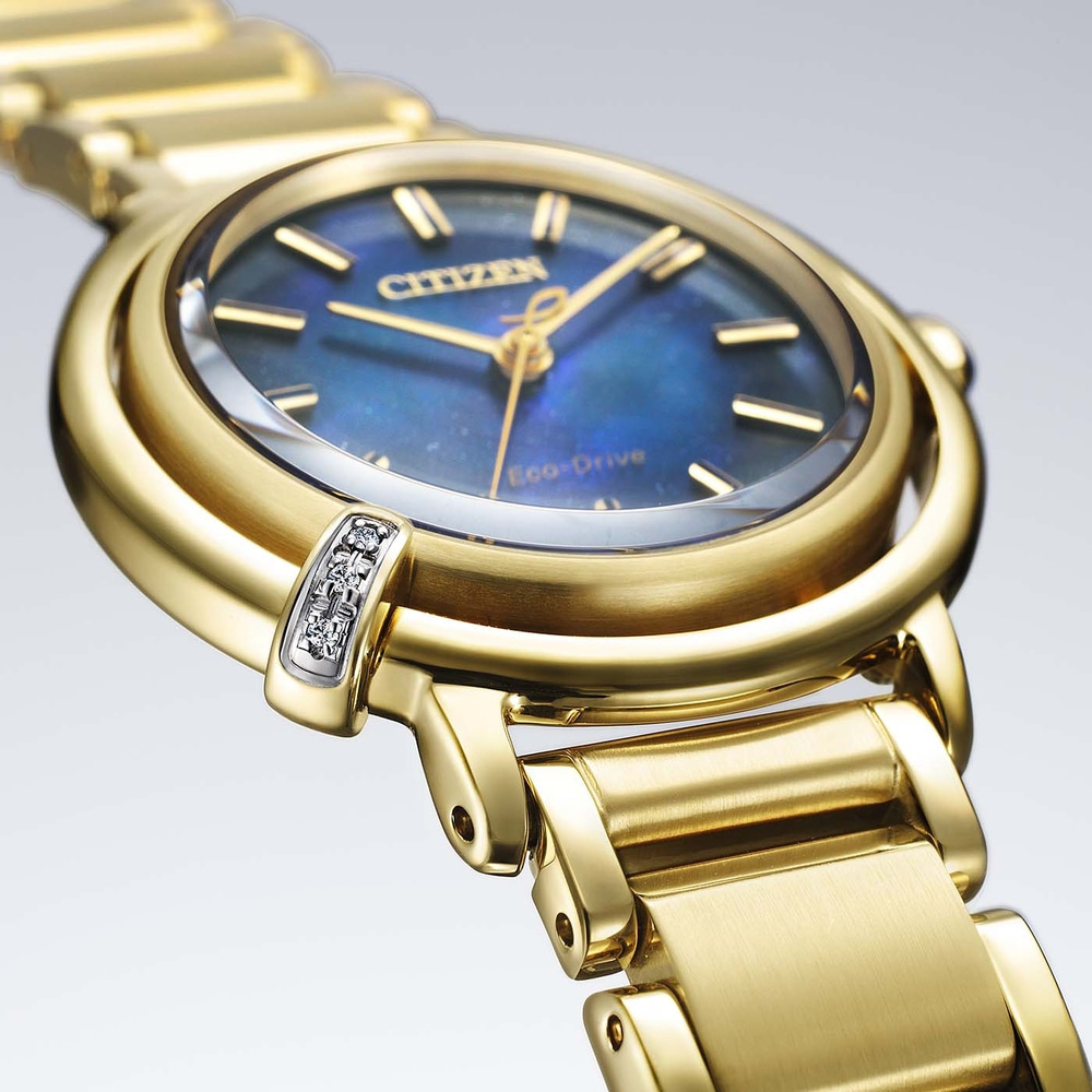 Gold Citizen Eco-Drive watch with blue face and diamond accents, close-up.