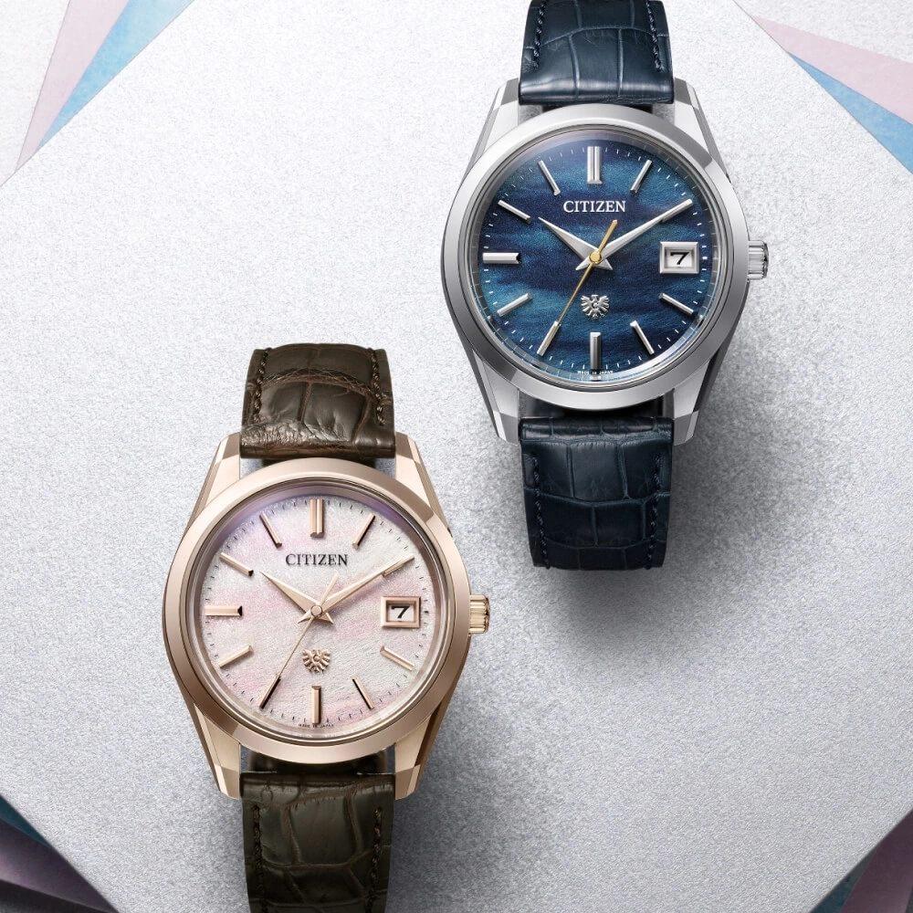 Two Citizen watches with leather straps on a white surface.
