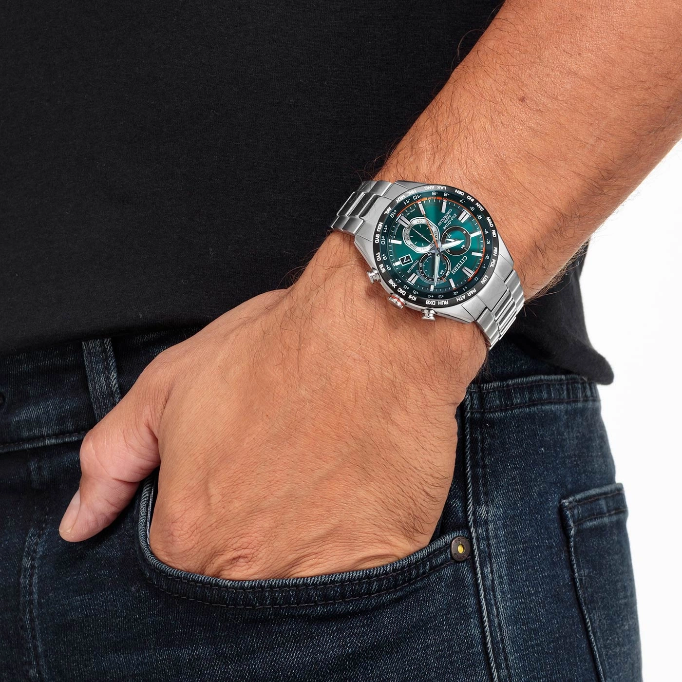 Man wearing a Citizen watch, hand in pocket, denim jeans, black shirt.