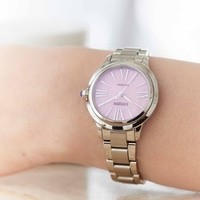 A close-up of a Citizen watch on a wrist, pink face, silver band.