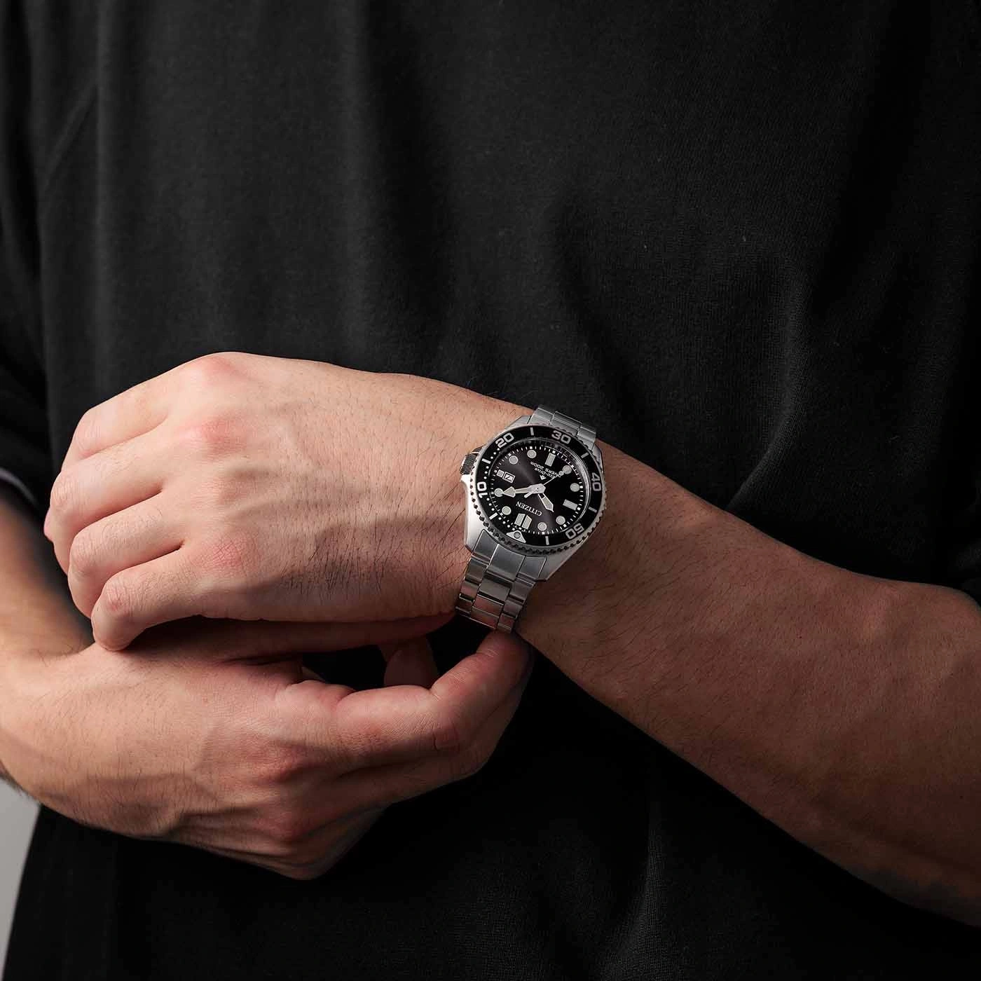 Man wearing a silver watch with a black face on his wrist