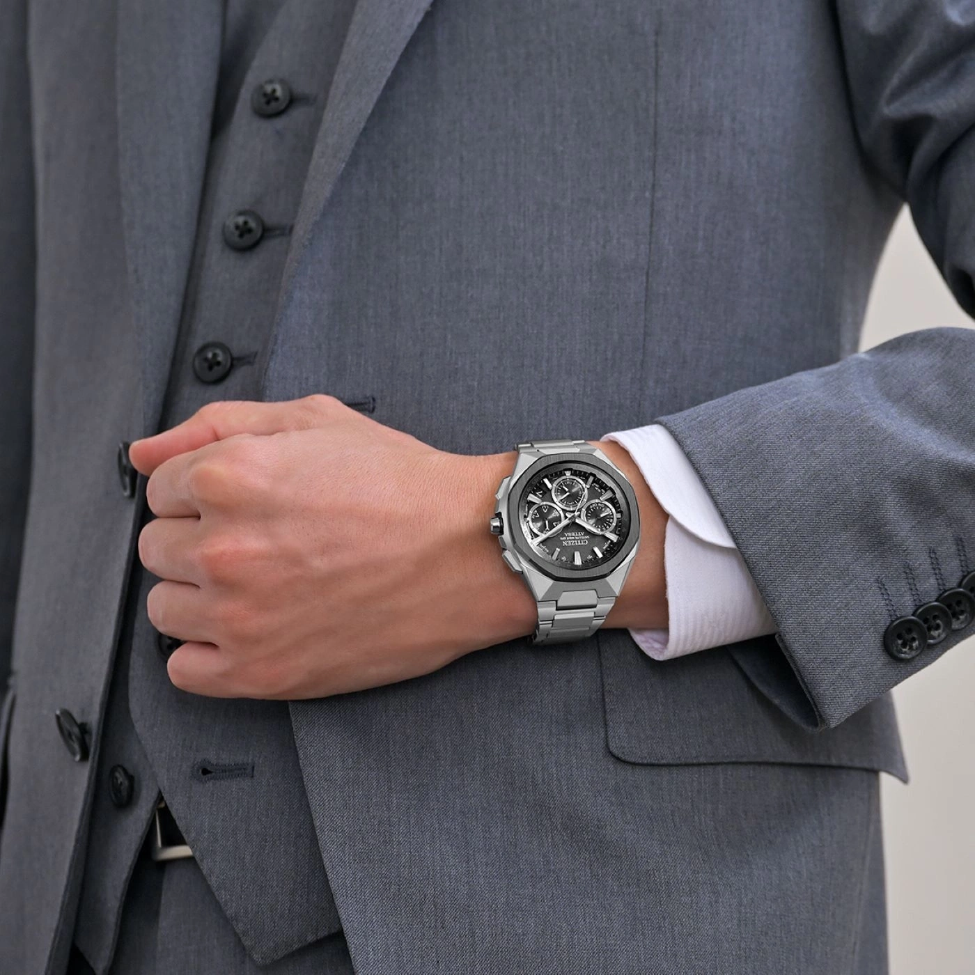 Man in suit wearing a silver watch. Formal attire and wrist watch.