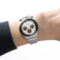 A man wears a silver Citizen chronograph watch on his wrist.