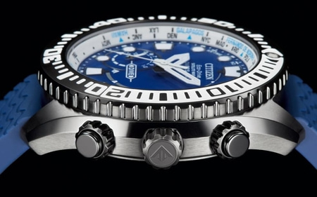 A close-up of a blue Citizen Eco-Drive watch with a blue rubber strap, showcasing its intricate details like the rotating bezel and multiple crowns.