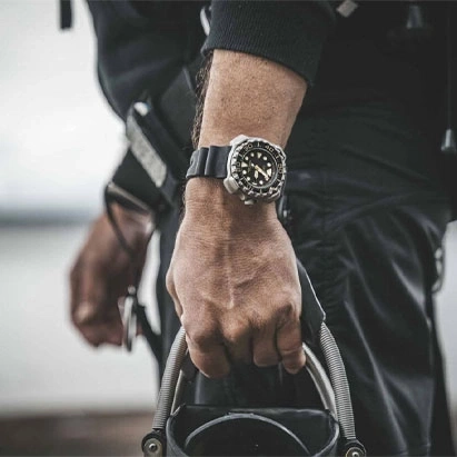 Man wearing a watch, holding equipment, close-up shot, black outfit