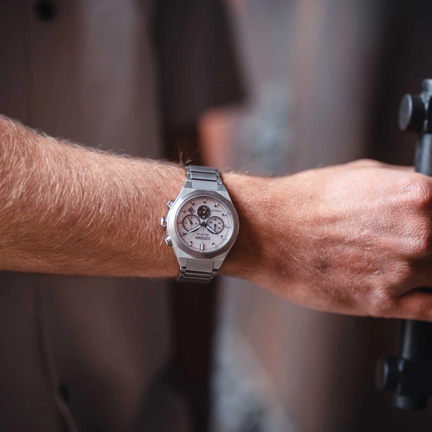 Close-up of a person's wrist with a silver Citizen watch.
