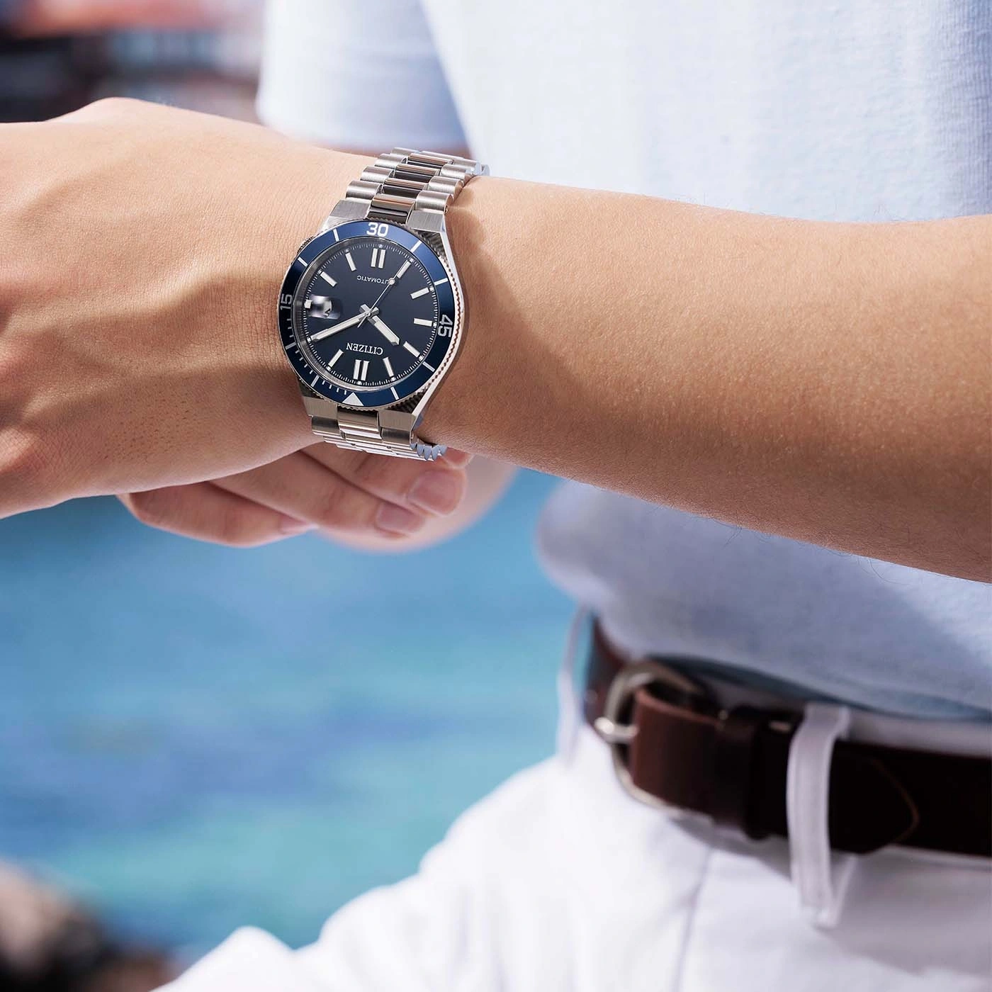 Man wearing a blue-faced Citizen automatic watch on his wrist.