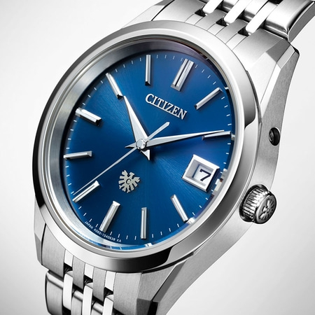 Citizen-Uhr mit blauem Zifferblatt, silbernen Zeigern und Markierungen, Datumsanzeige und Metallarmband.