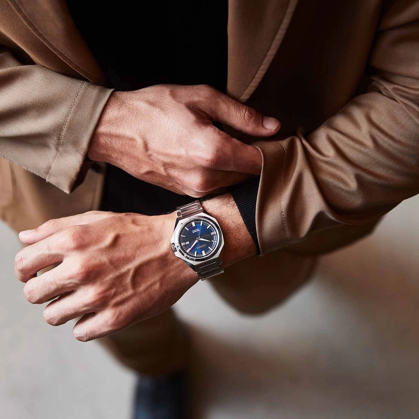 Man wearing a watch, hands on a brown jacket, close-up shot