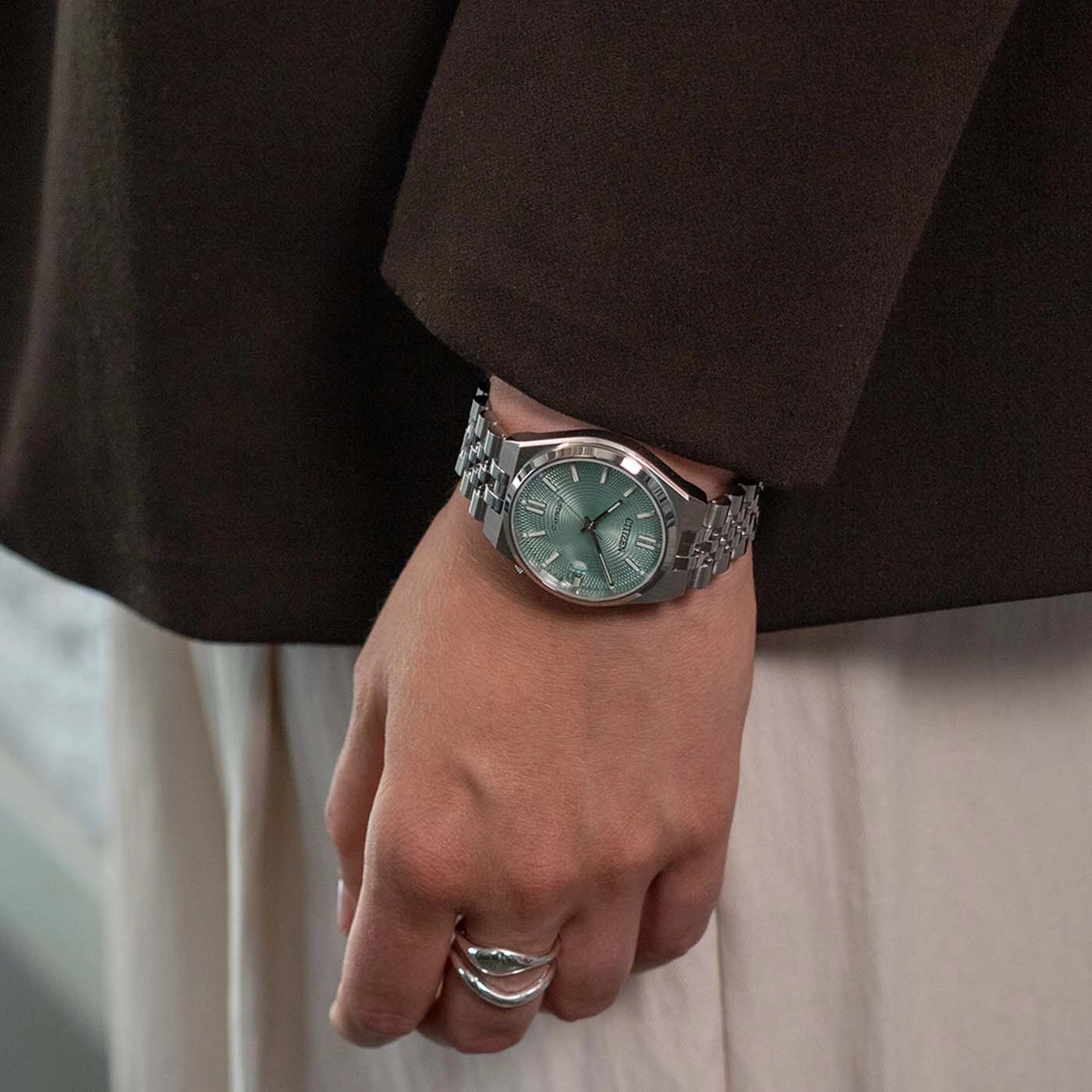 A person wearing a watch and rings