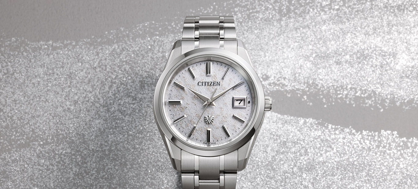 Citizen-Uhr mit silbernem Armband und weißem Zifferblatt, mit der Zahl 7 sichtbar.