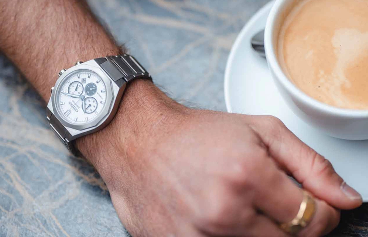 Man wearing a Citizen watch with a cup of coffee on the side