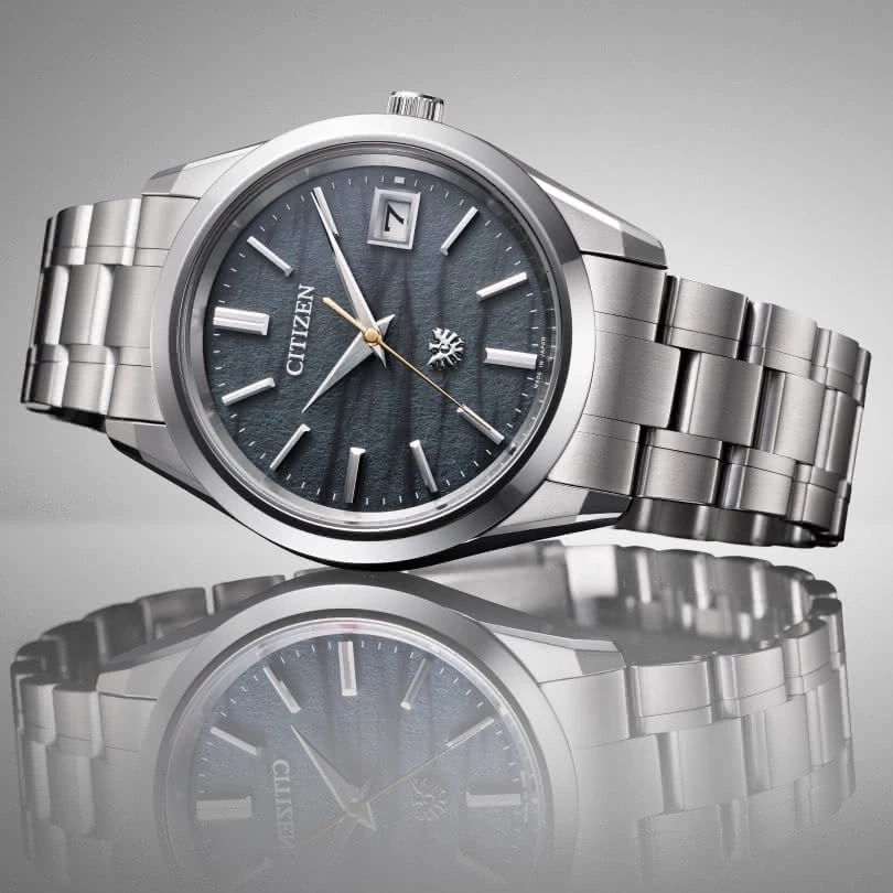 Citizen watch with a dark dial and silver bracelet, elegant design.