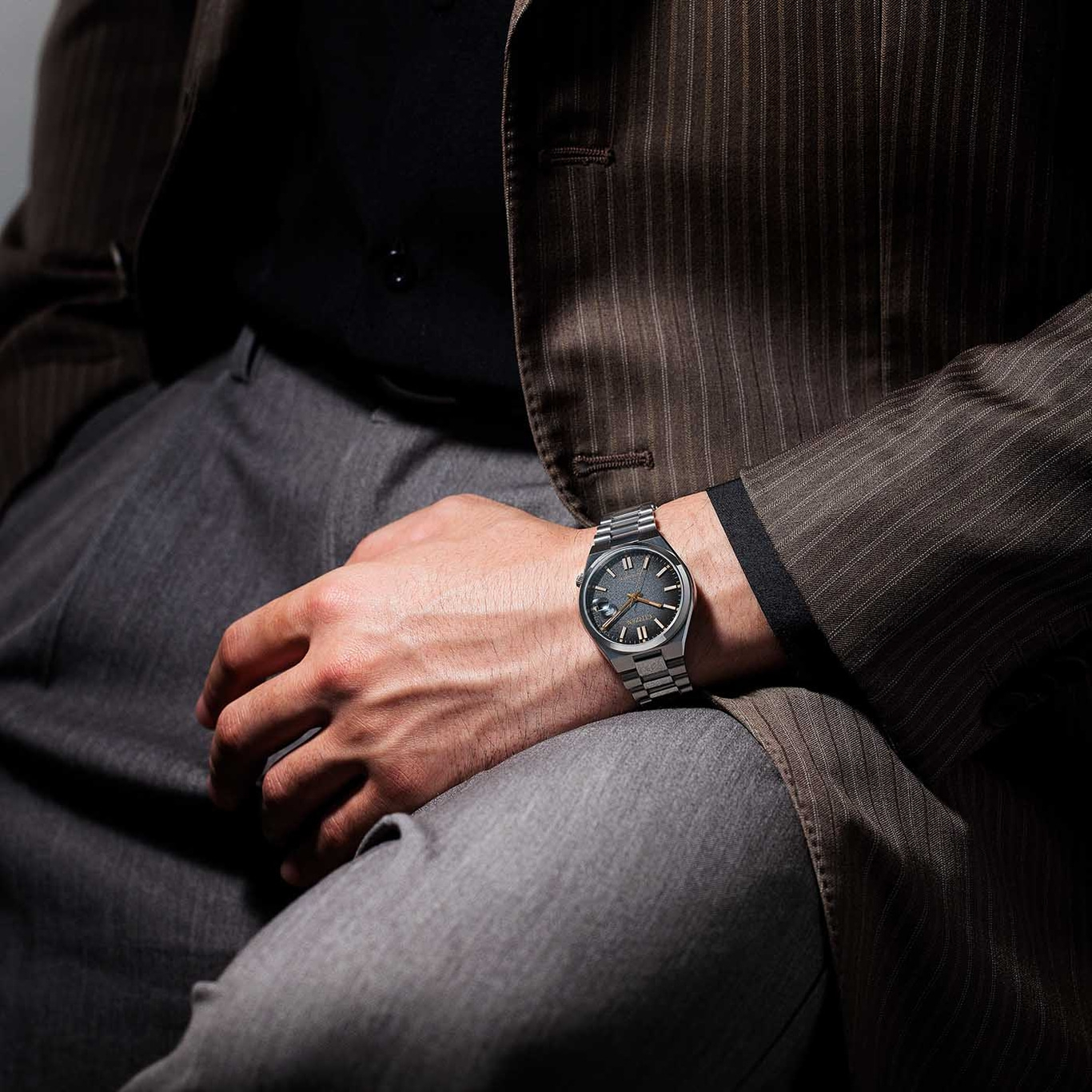 Man wearing a watch, suit, and pants. Wristwatch on the wrist.