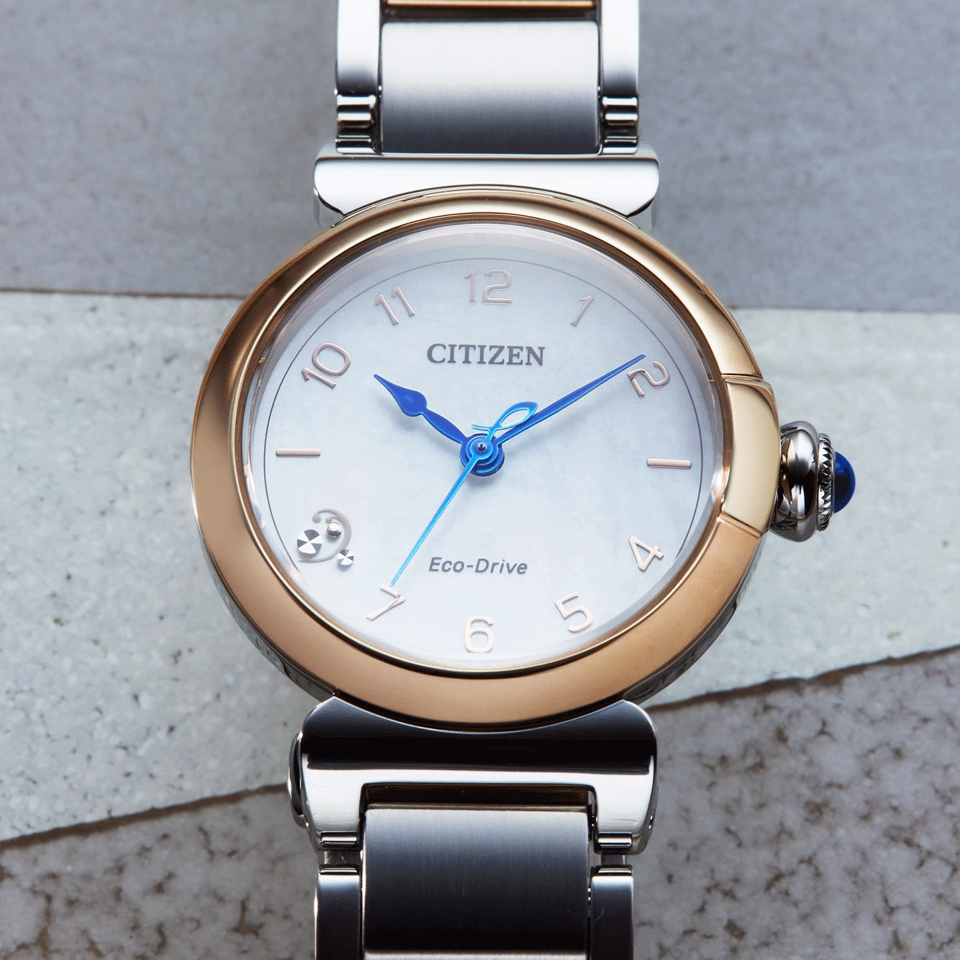 Citizen Eco-Drive watch with a gold and silver band and blue hands.