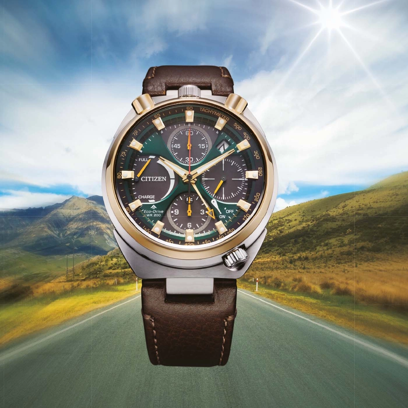 A Citizen Eco-Drive watch on a scenic road with mountains and sun.
