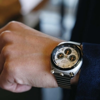 A man's wrist wearing a silver Citizen chronograph watch.