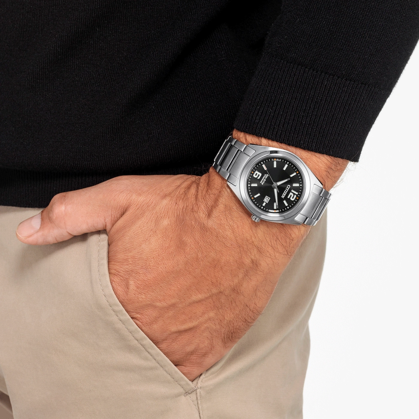 Man wearing a Citizen watch, black sweater, and tan pants.