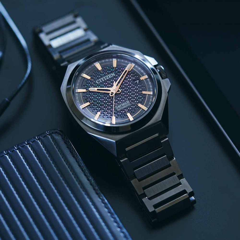 Citizen Series 8 automatic watch on a dark surface with a wallet.