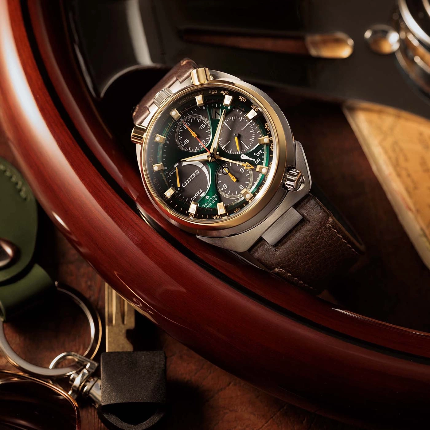 A luxury watch and car keys on a polished wooden surface.