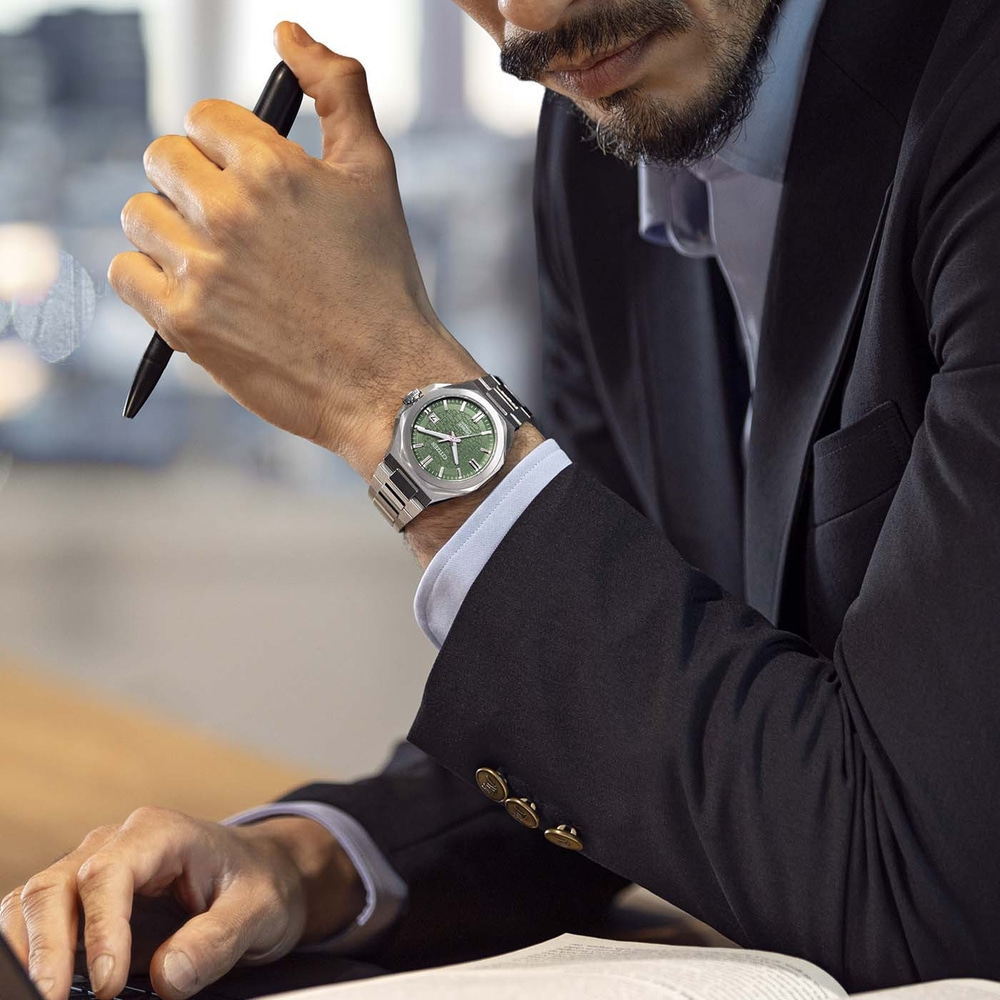 Man in suit with watch and pen at desk