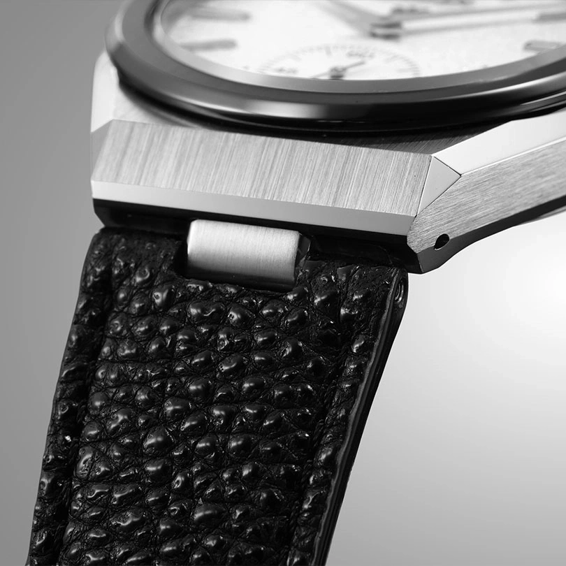 Close-up of a watch with a black leather strap and a silver case.