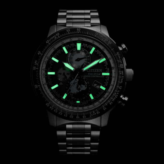 Citizen Eco-Drive watch with glowing hands and markers on a black background.