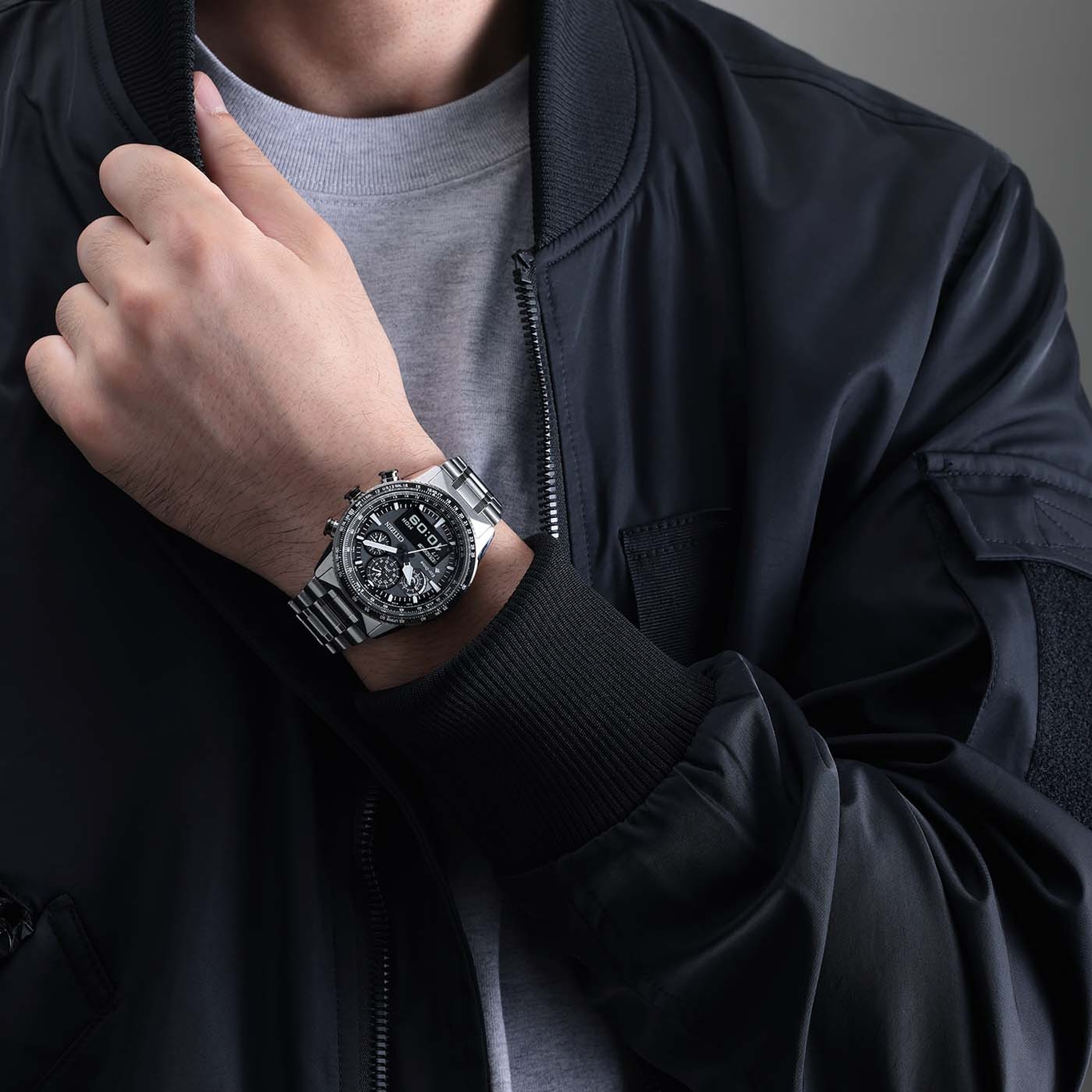 Man wearing a watch and a black jacket, close-up shot.