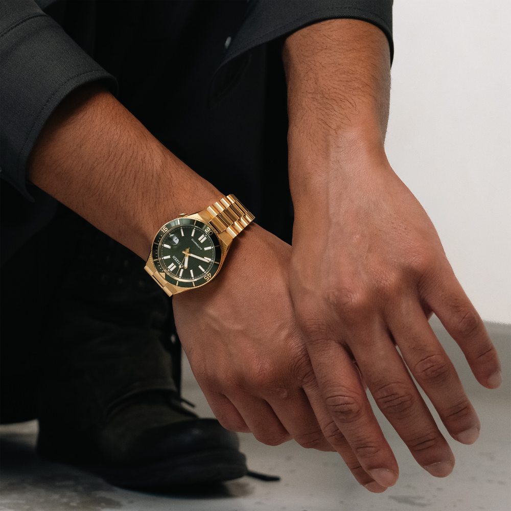 Man wearing a gold watch on his wrist, close-up shot.