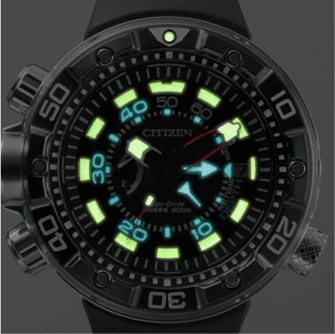 Close-up of a Citizen Eco-Drive dive watch with luminous hands and markers, black bezel.