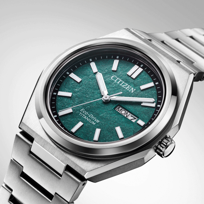 Citizen watch with green face and titanium band, close-up shot.