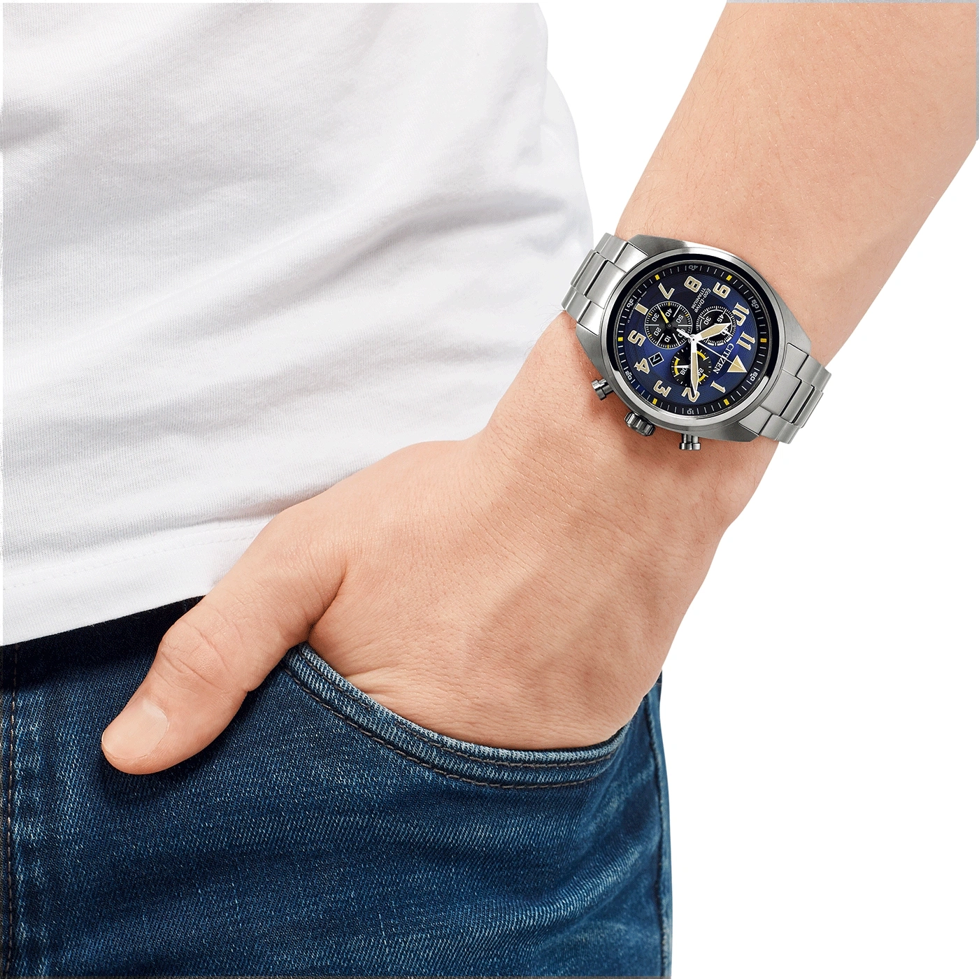 Man wearing a silver watch with a blue face, hand in pocket.