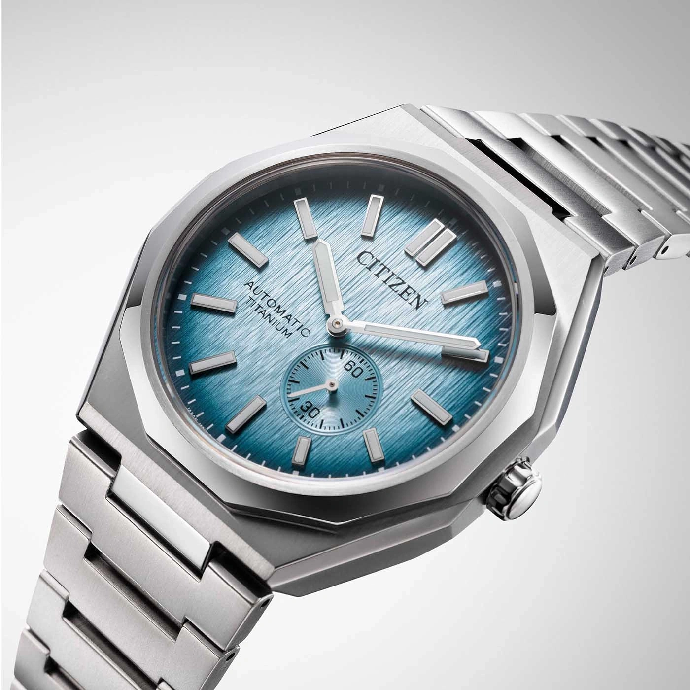 Citizen watch with blue face and titanium strap, automatic movement.
