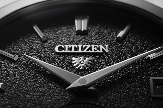 Nahaufnahme eines Citizen-Zifferblatts mit Zeigern und Logo in Schwarzweiß.