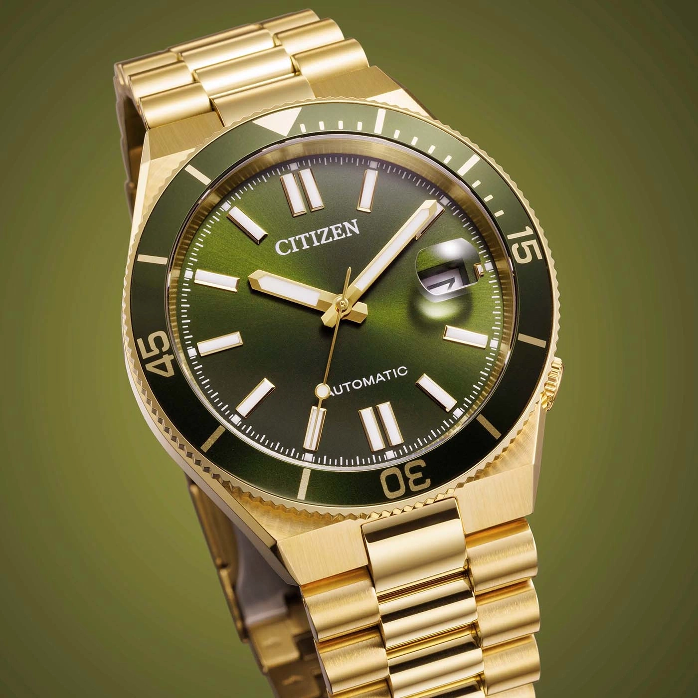 A gold Citizen automatic watch with a green dial and bezel.