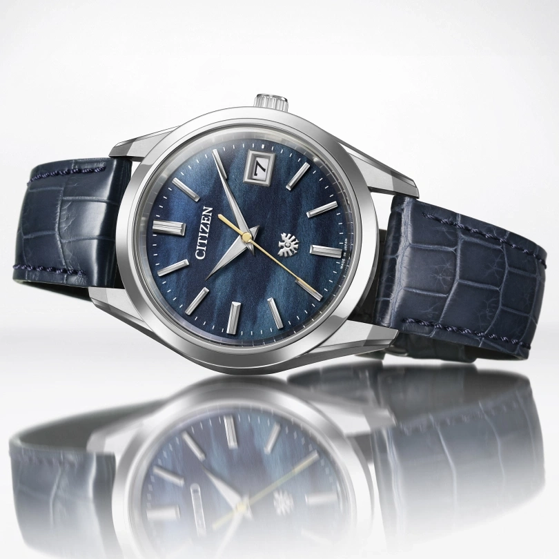 Citizen watch with blue face and leather strap, elegant design, date display.