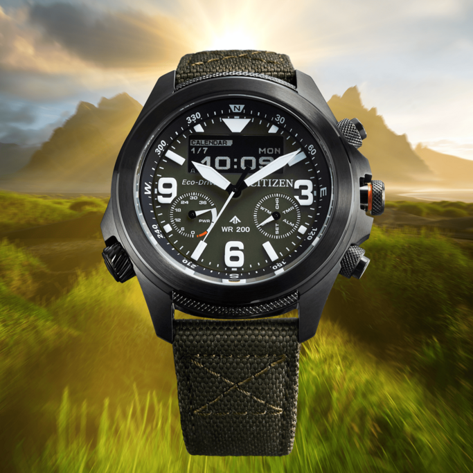 Citizen watch with digital display, black case, and green fabric strap.
