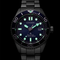 Citizen watch with luminous hands and markers, black bezel, blue dial, and date display.